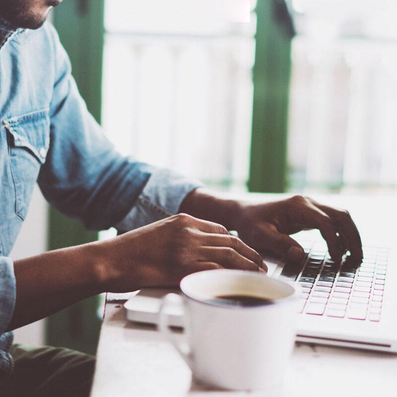 Man checks his compliance status while sitting at a countertop.